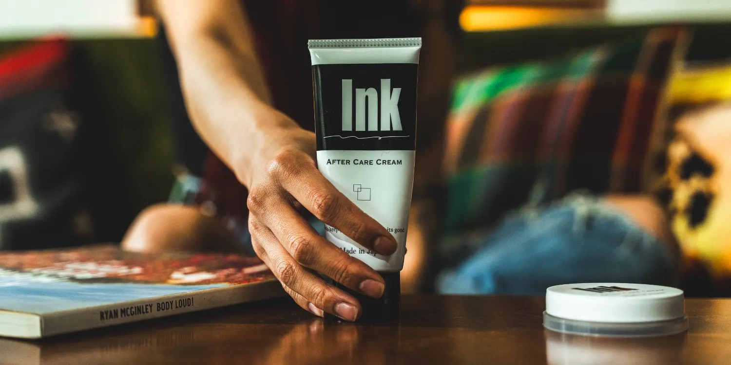 Inkcare のアフターケアクリームを手に取る様子