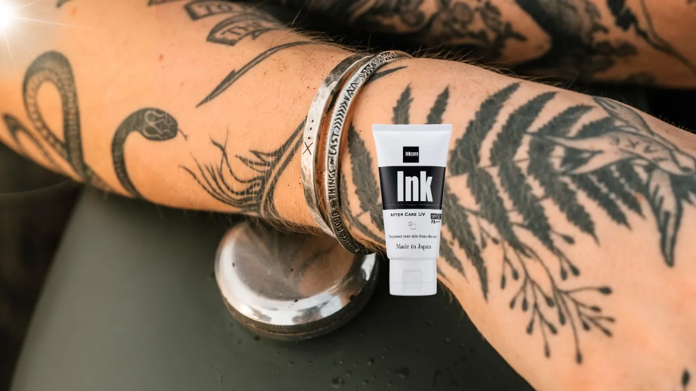 タトゥーの入った腕の上に置かれた Inkcare アフターケアUV